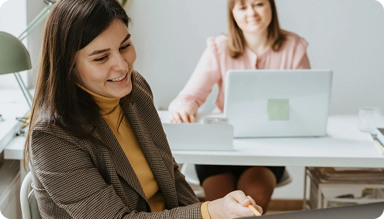 Deux femmes dans un open space travaillant sur des ordinateurs portables